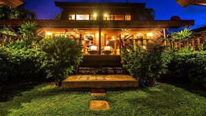 A two-story house with a well-lit entrance and a garden in front. - Erawan Villa Hotel (Koh Samui)