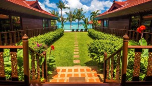 A pathway leading to a beach with palm trees and a clear sky. - Erawan Villa Hotel (Koh Samui)