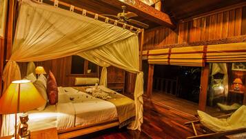 A room with a bed, a nightstand, a chair, and a balcony with a view.