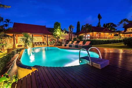 Una piscina al aire libre, camas de piscina gratis, sombrillas