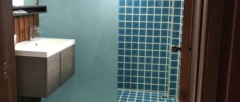A bathroom with a tiled floor, a sink, and a toilet.