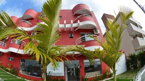 A red building with balconies and a sign that reads "Portal do Sol". - Pousada Portal do Sol (Bombinhas)