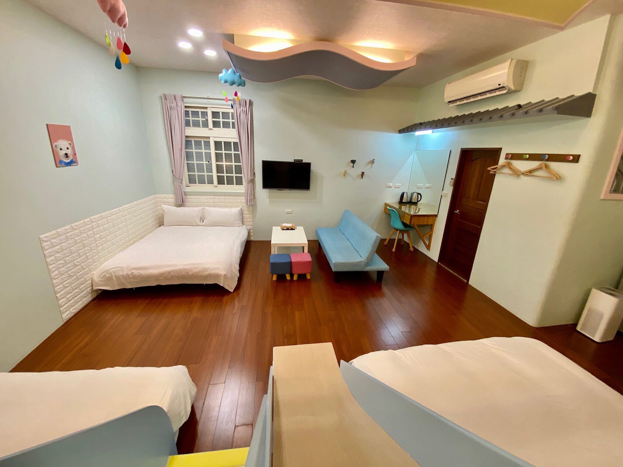 A bedroom with a bed, a desk, a TV, and a wardrobe.