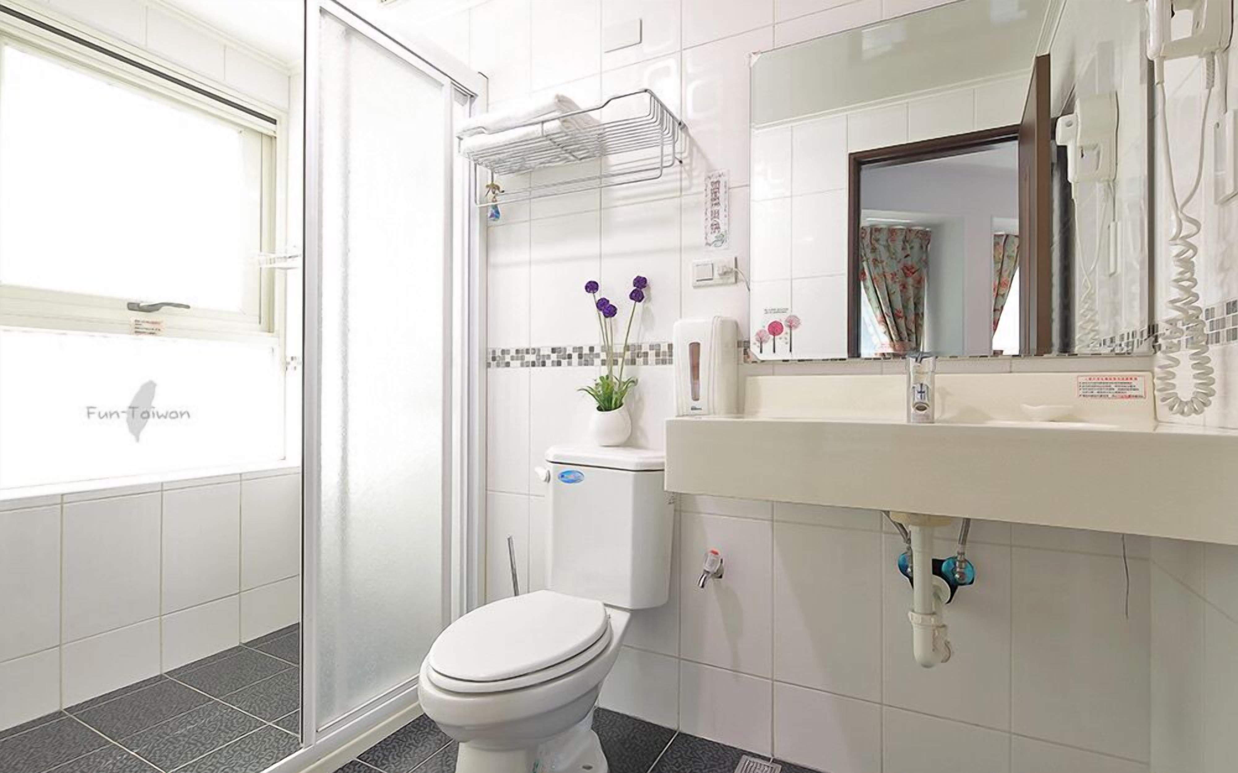 Un baño moderno con inodoro, ducha y lavamanos.