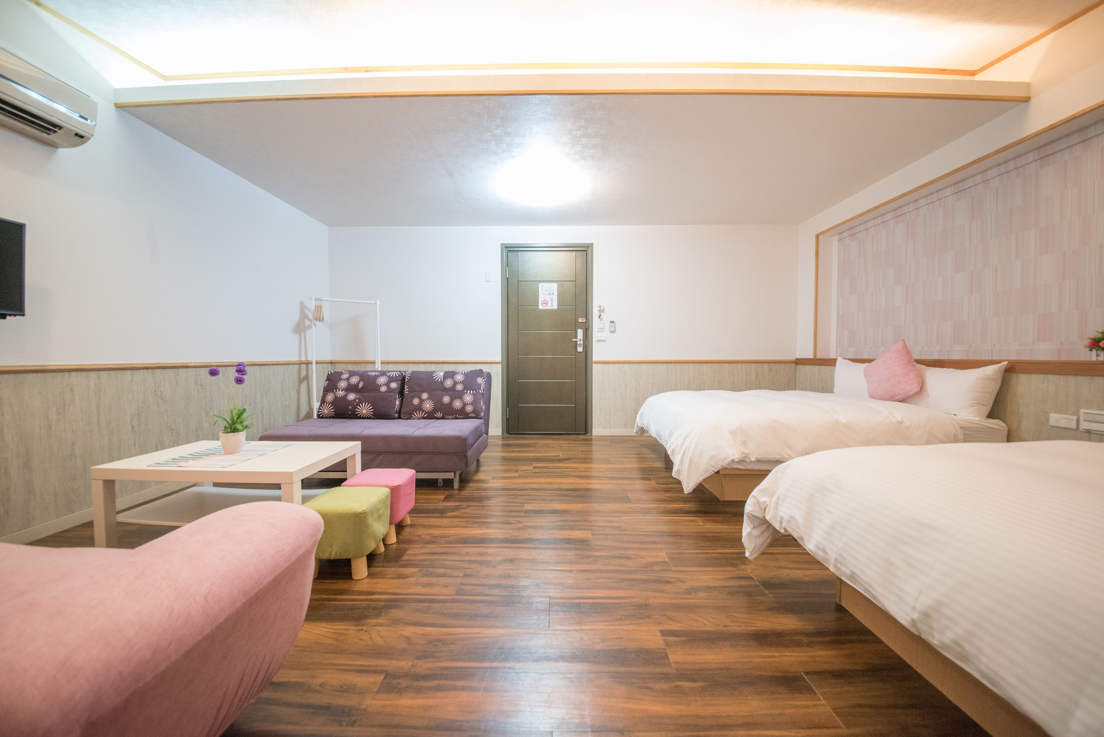 Una habitación de hotel con dos camas, un sofá, una mesita y una silla.