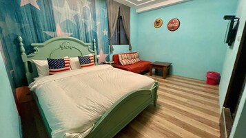 Un dormitorio con una cama, un sofá rojo, una mesita y una pared con dos botellas decorativas.