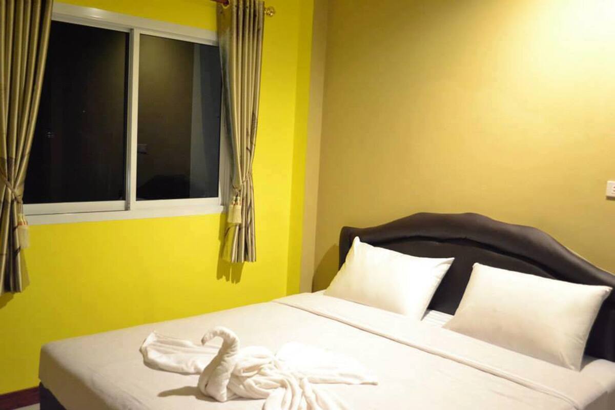 Una habitación de hotel con cama, cortinas y ventana.