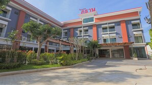 A multi-story hotel with a red and white facade, balconies, and a covered entrance area. - Phuthan Hotel (Tha Chang)