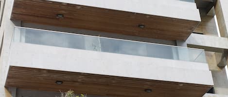 A multi-story building with a modern architectural design, featuring large glass windows and wooden beams.