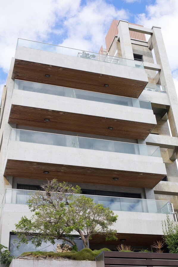 Un edificio de varios pisos con un diseño arquitectónico moderno, que cuenta con amplios ventanales y vigas de madera.