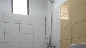 Une petite salle de bain avec des toilettes, une douche et un lavabo.