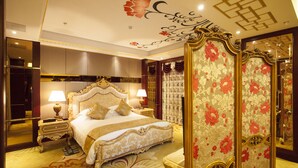 A luxurious bedroom with a large bed, ornate headboard, and a decorative mirror. - Waijing Gloria Grand Hotel Anhui (Wuhu)