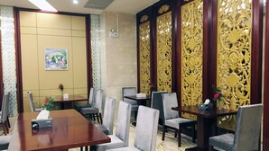 A conference room with a wooden table, grey upholstered chairs, and a decorative golden partition. - Waijing Gloria Grand Hotel Anhui (Wuhu)