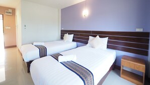 A hotel room with two beds, a wooden headboard, a nightstand, and a wall-mounted light fixture. - Nan For You Resort (Phu Phiang)