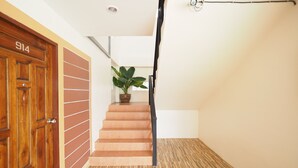 A wooden door with the number 914, a staircase with a potted plant, and a striped floor. - Nan For You Resort (Phu Phiang)
