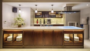 A modern kitchen with a large island, built-in appliances, and pendant lighting. - Maison De Camille Boutique Hotel (Ho Chi Minh City)