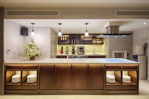 A modern kitchen with a large island, built-in appliances, and pendant lighting.
