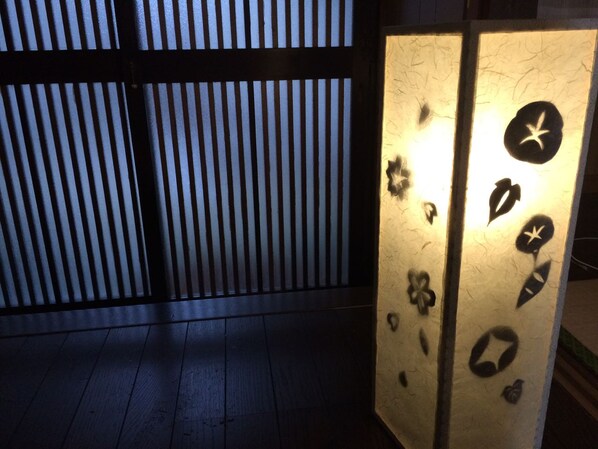A room with a wooden floor and a sliding door with decorative cutouts.