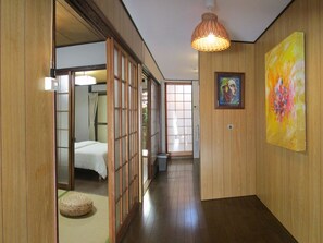 En gang med trævægge, en seng i baggrunden og et billede på væggen.