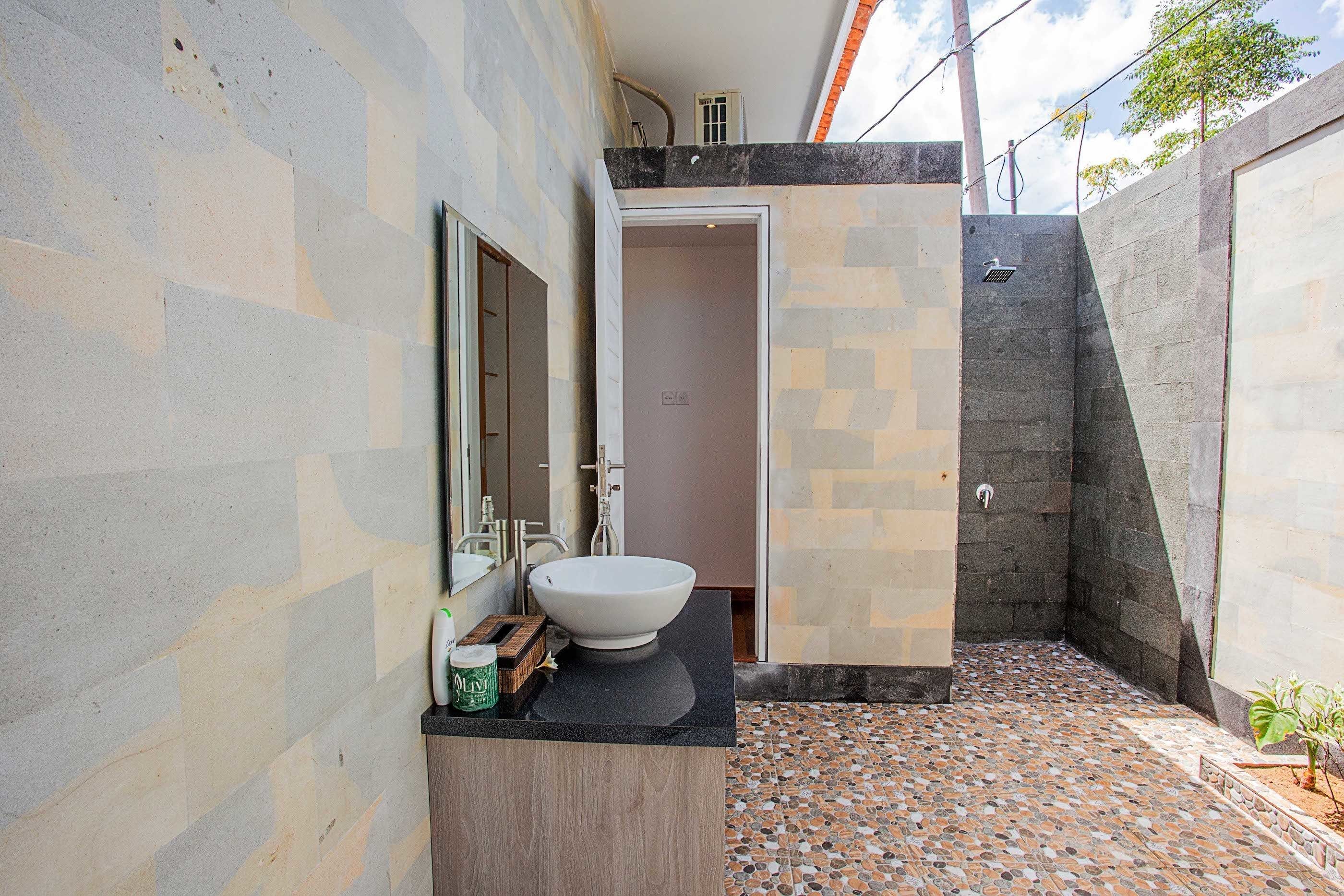 Un baño moderno con un lavamanos grande, un espejo y una zona de ducha.