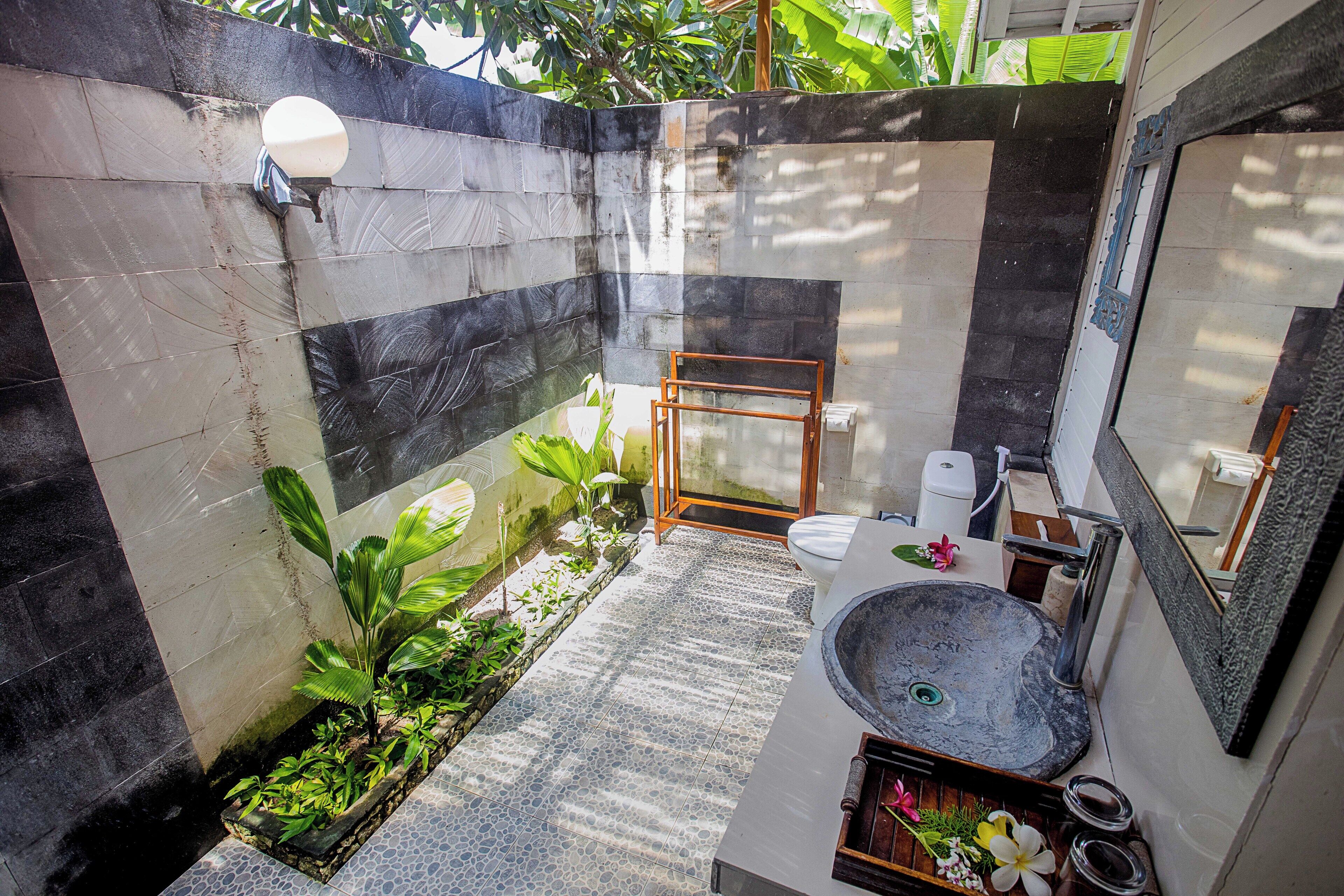 Un baño pequeño con un lavabo de piedra, un espejo y una zona de ducha.