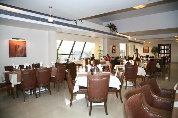 Un comedor espacioso con techos altos, ventanas amplias y una decoración moderna.