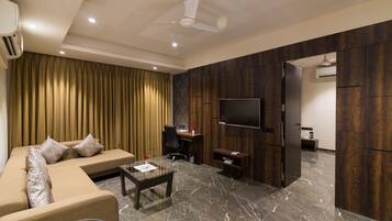 Suíte superluxo, 1 cama King | Área de estar | TV de tela plana 32 polegadas com canais a cabo, TV