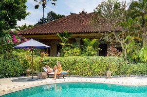 Una piscina al aire libre, sillones reclinables de piscina