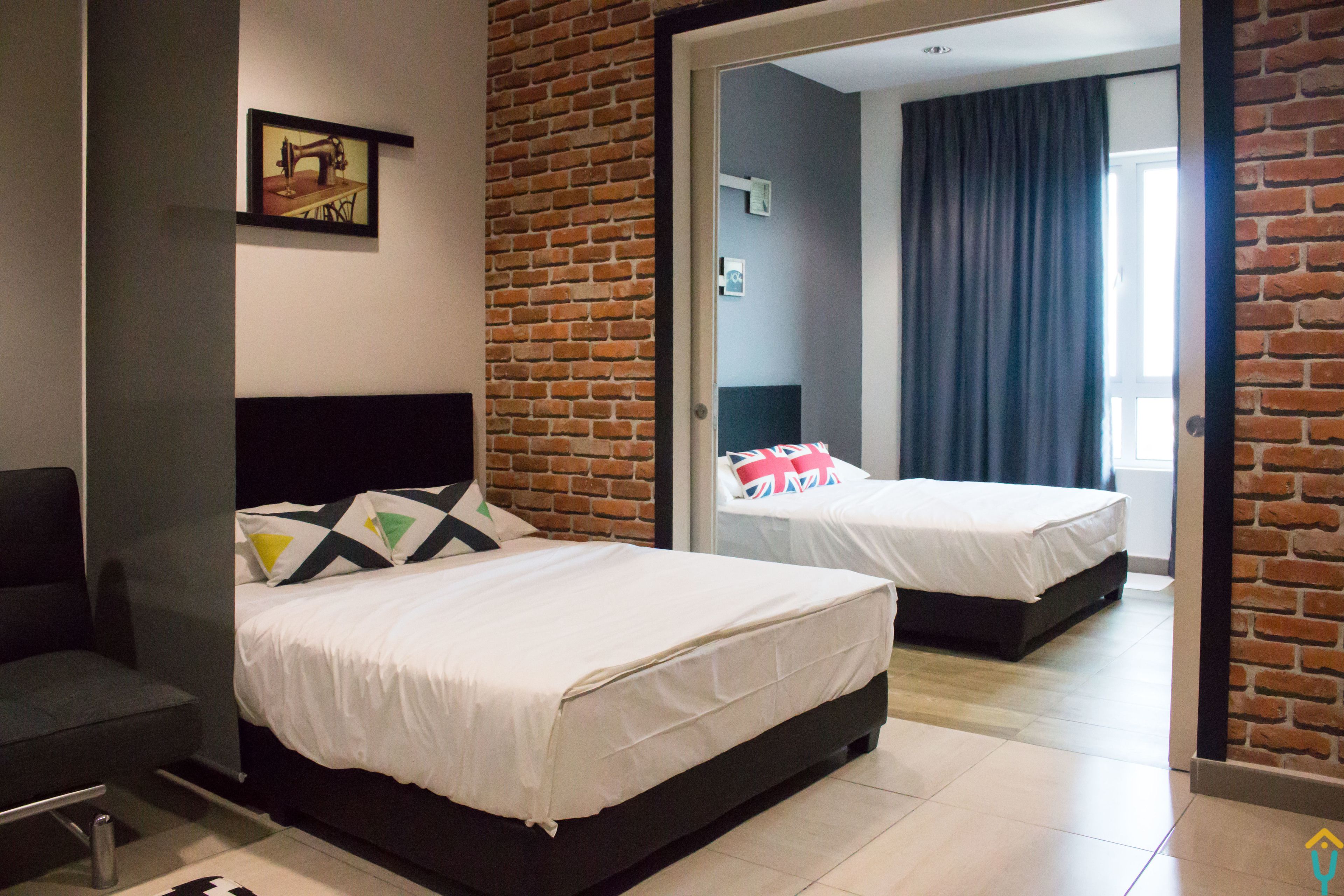 A hotel room with two beds, a brick wall, and a modern design.