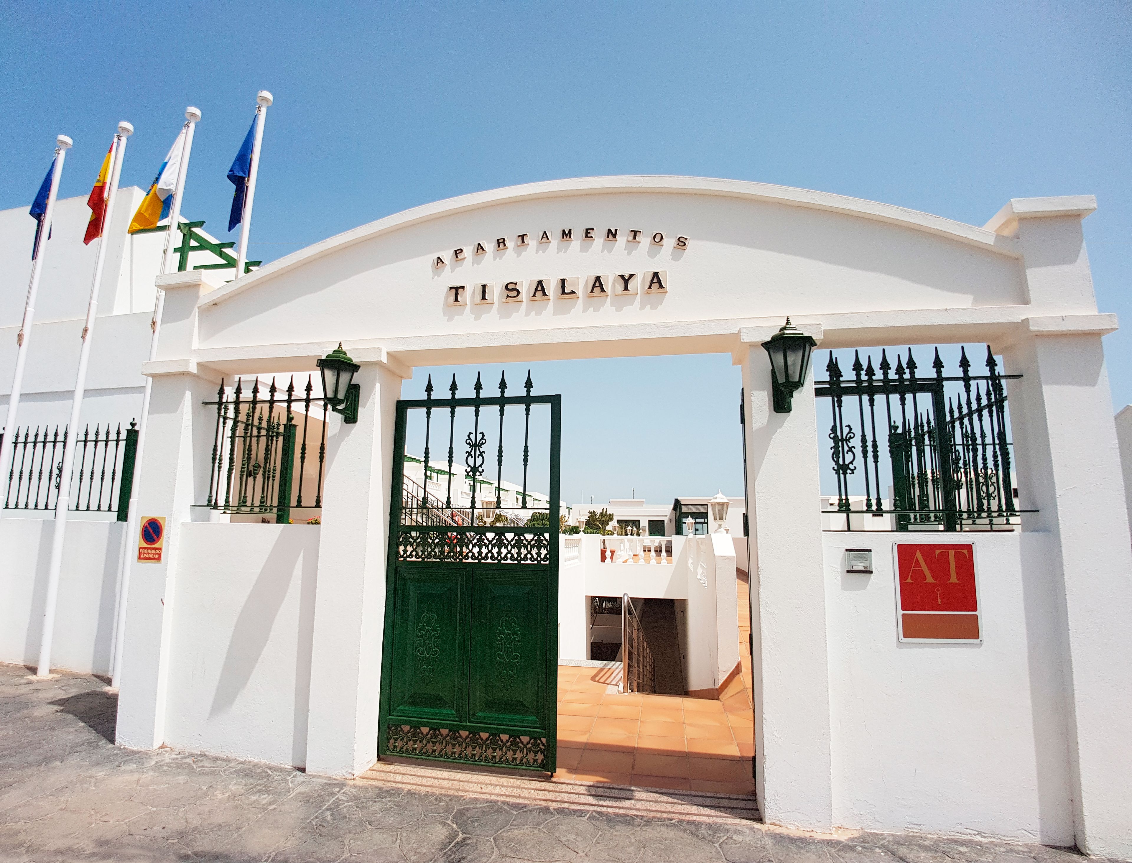A gated entrance to a building with the sign "APARTAMENTOS TISALAYA".