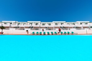 A hotel with a swimming pool, multiple balconies, and a clear blue sky. - Apartamentos Tisalaya (Tías)