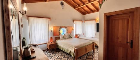 A cozy bedroom with a wooden ceiling, a bed, a nightstand, a table, and a patterned rug.
