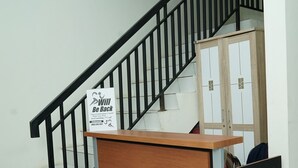 Una escalera con barandal negro y un mueble de madera con cajones en la parte inferior.