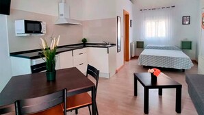 A compact, modern apartment with a kitchenette, a dining area, and a bedroom. - Complejo Bubal Formigal 3000 (Biescas)