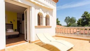 A room with a bed, a window, and a balcony with a sun lounger. - Mas Picton (Argelès-sur-Mer)
