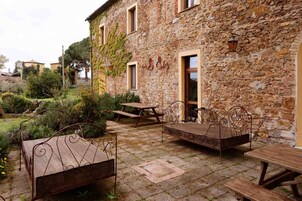 A stone building with outdoor seating and a garden.
