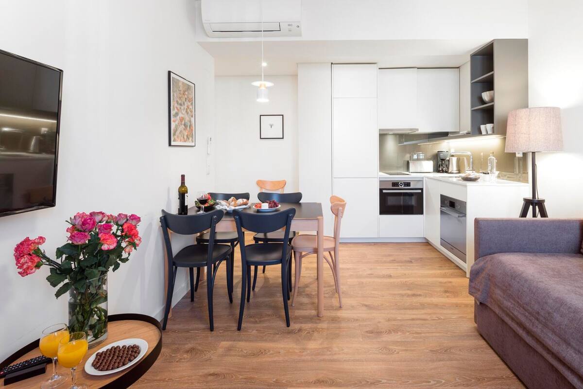 Un espacio habitable compacto con comedor, kitchenette y sofá.