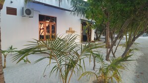A white building with a wooden-framed window and a sign reading "ITHA BEACH Maldives". - Ithaa Beach Maldives (Guraidhoo)