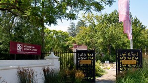 A pathway leading to a botanical garden entrance with a sign indicating it is part of the University of Stellenbosch. - 10 Alexander B&B (Stellenbosch)