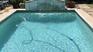 Guests can enjoy a refreshing swim in the pool surrounded by lush greenery.