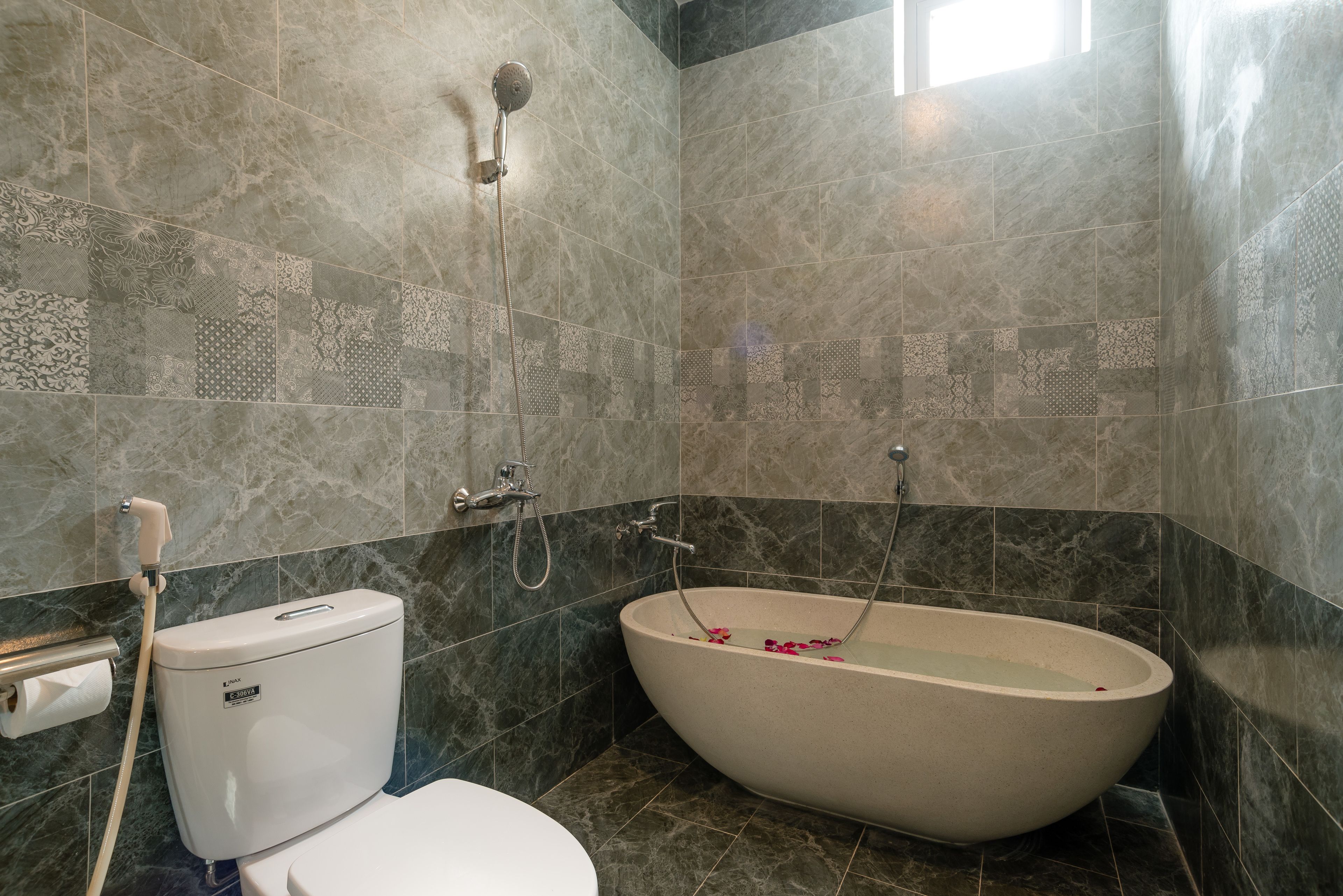 A bathroom with a freestanding bathtub, a toilet, and a shower.