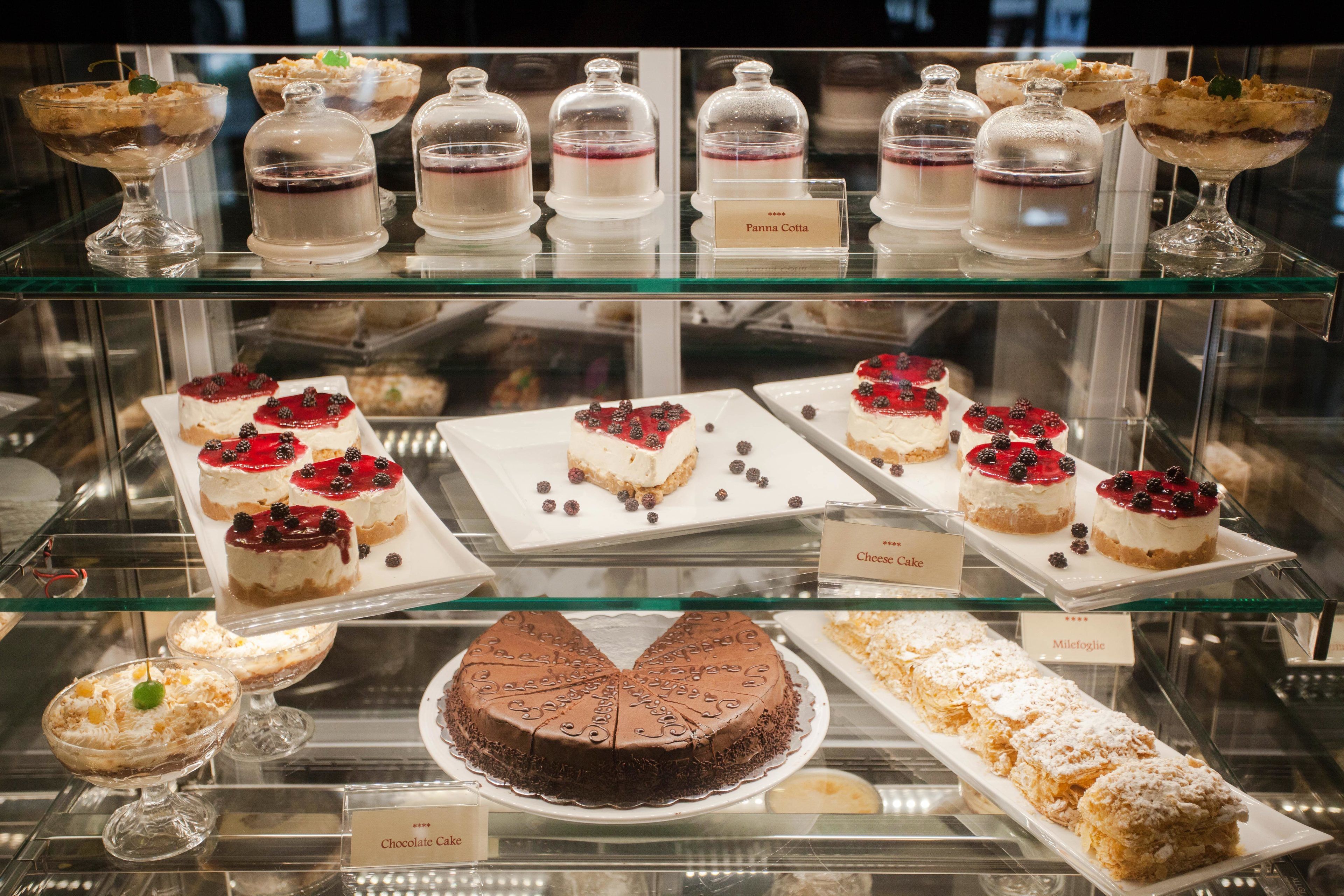 Een desserttafel met verschillende taarten en gebak, waaronder chocoladetaart en een mille-feuille.