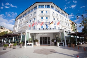 A hotel with a classical facade, multiple flags, and a central entrance. - Hotel Colosseo Tirana (Tirana)