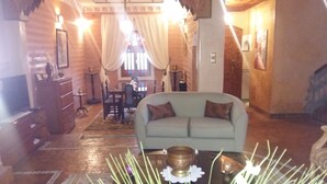 Ein gemütliches Wohnzimmer mit einem hellblauen Sofa, einem Couchtisch mit einer Messing-Schale und einem Essbereich mit Tisch und Stühlen.