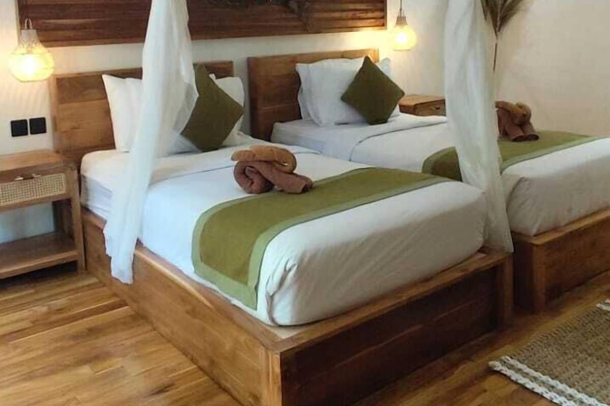 A four-poster canopy bed with wooden headboard and footboard, two bedside tables, and a nightstand.