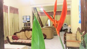 A living room with a sofa, armchairs, and a coffee table. There is a staircase in the background leading to another level. - Pura Sanda Villa (Inamaluwa)
