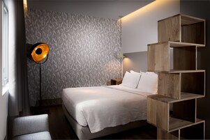Quarto com cama, mesa de cabeceira, luminária e estante de madeira.