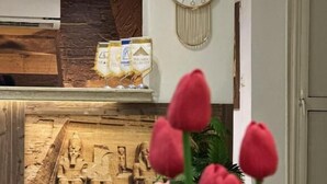 A reception area with a wall-mounted clock, a display of products, and a decorative wall with a relief sculpture. - Giza Pyramids Inn (Giza)