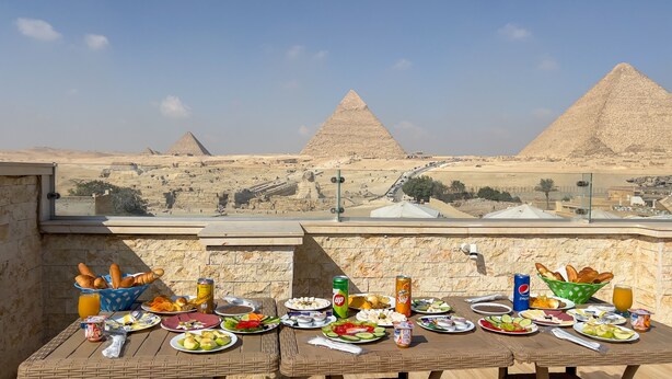 A table set with food and drinks, overlooking the pyramids. - Giza Pyramids Inn (Giza)