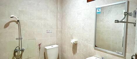 Un baño con inodoro, ducha y lavamanos.
